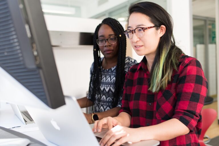 Two women working on laptop work and study in Canada