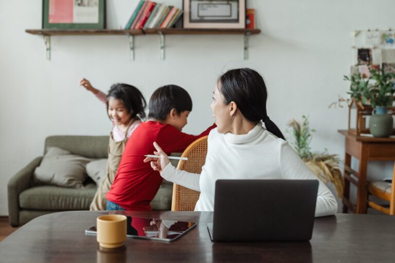 Women working in Canada with her family and kids playing behind her